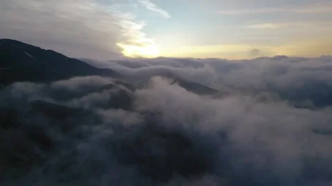 High snowy mountains covered with dense haze, blue sky with clouds at dawn. Stock Footage 253874442