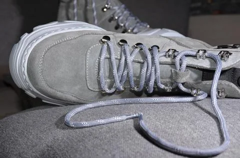 High-soled boots on a gray background. Gray laces on the boots. Stock Photos