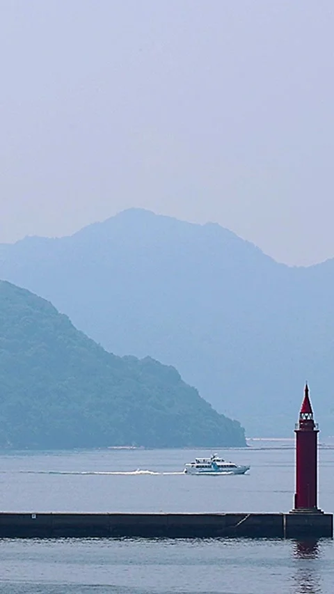 High-Speed Boat Passing Dragon Island and a Lighthouse on the Seto Inland Sea 库存影片 340830648