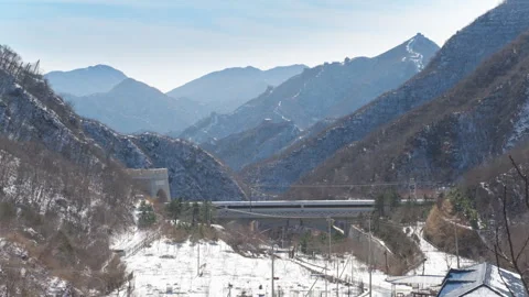 High Speed Bullet Train Passing through Juyongguan Great Wall in Snow Stock Footage 330987125