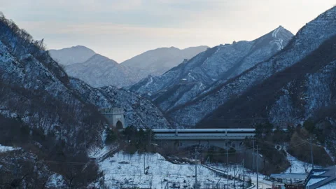 High Speed Bullet Train Passing through Juyongguan Great Wall in Snow Stock Footage 331004272