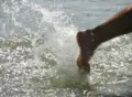 High speed camera : Girl steps into ocean waves Footage
