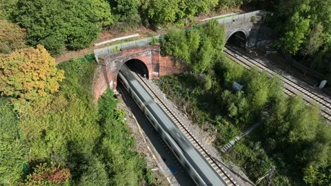 High Speed Commuter Train Entering a Tunnel Transporting Passengers Stock Footage 213036573