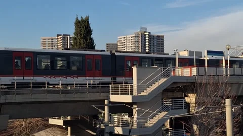 High-Speed Commuter Train Passing Urban Station Platform Stock Footage 329748705