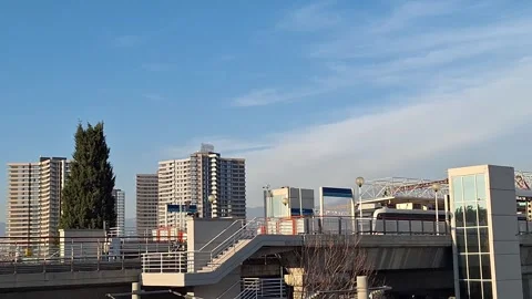 High-Speed Commuter Train Passing Urban Station Platform Stock Footage 329748716