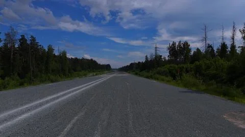A high-speed flight over a road construction site surrounded by forest and .. 스톡 사진