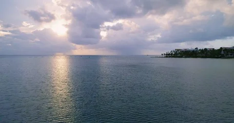 High speed fly over water with island cliff palm trees in sight Stock-Footage 97182272