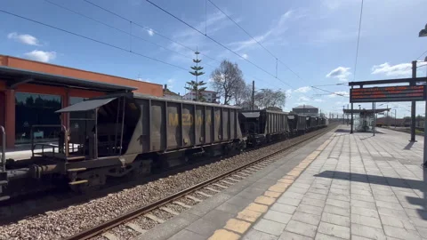 A high-speed freight train passes by the station at high speed in Estarreja Stock Footage 238770153