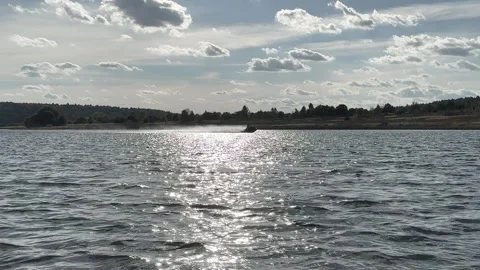 High speed jet ski on river, horizon of waves with sun reflection and clear sky Stock Footage 289735273