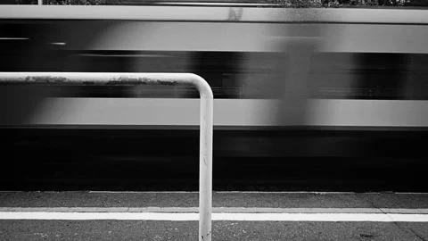A high-speed passenger train rushes past at the railway station. Stock Footage 133495329