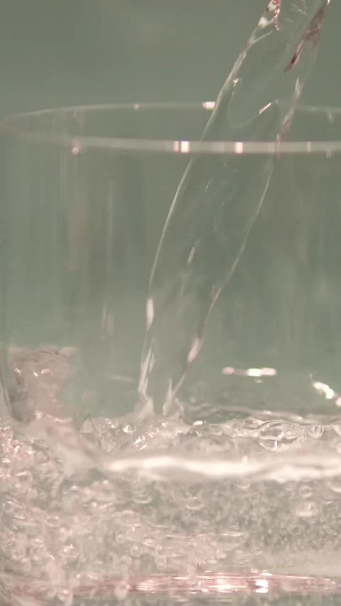High speed shot close up of clear mineral water pouring into drinking glass Stock Footage 323920603
