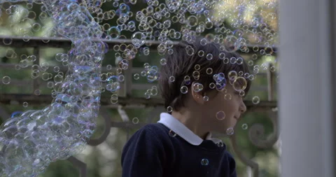 High-Speed Slow-Motion of Boy Surrounded by Countless Soap Bubbles Stock Footage 254819954