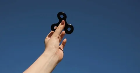 A high speed spinning hand spinner or fidget spinner over the sky background. Vídeo Stock 76633997