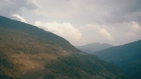 High Speed Sun pass from cloud against Huge Mountain have small village Stock Footage 154017294