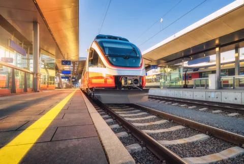 High speed train on the modern railway station at sunset in summer in Graz,.. Stock Photos