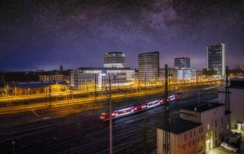 High speed train in motion and Milky Way at starry night. Industrial landscap Stock Photos