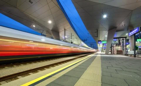 High speed train in motion on the railway station at night. Moving red mode.. Stock Photos
