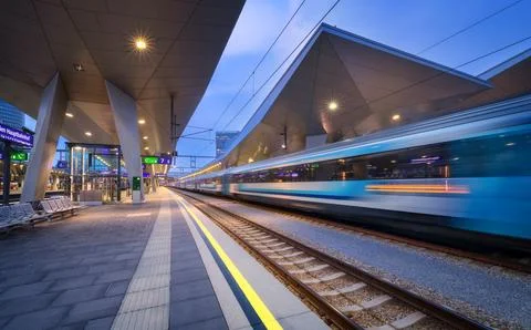 High speed train in motion on the railway station at night. Moving blue mod.. Stock Photos