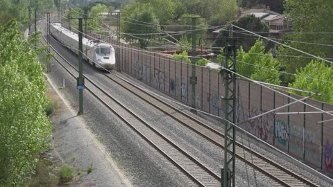 High speed train moves away through wooded area Stock Footage 239677420