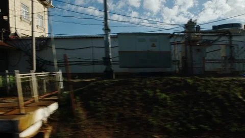 High-speed train moves past an industrial zone in the summer Stock Footage 119352138