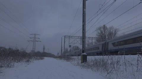 High speed train passing by on a snowy evening Video stock 148112833