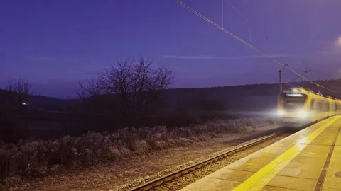 High-Speed Train Passing Through Rural Station At Dusk With Motion Blur 스톡 동영상 295028375