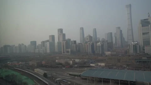 A high-speed train running past Beijing's CBD on a pollution day Stock Footage 234371879