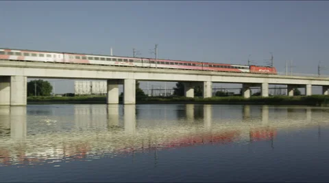 High speed train on viaduct with mirrored image in the water Stock Footage 42724345