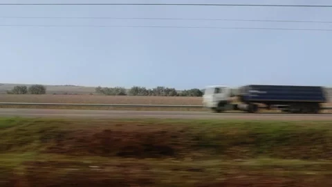 High-speed transit showing parallel highway traffic. Trucks and autos move Видео 320605990