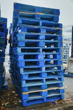 High stack of blue wooden shipping pallets in warehouse yard Stock Photos