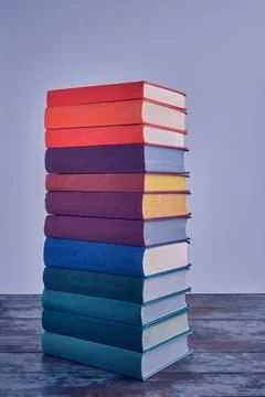 A high stack of bright thick books in multi-colored fabric covers, on a shabb Fotos Stock