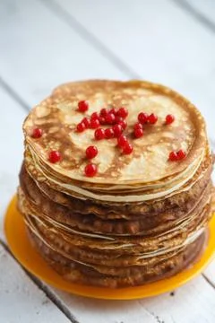 High stack of classic Russian thin pancakes with red currant berries . Rustic Stock Photos