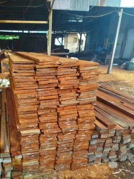 High stack of processed timber boards and wooden planks at a sawmill workshop Stock Photos