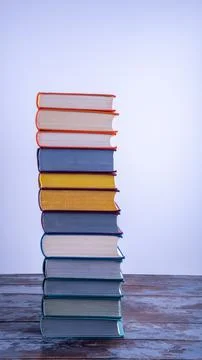 A high stack of used books in fabric bright multi-colored covers with texture 写真素材