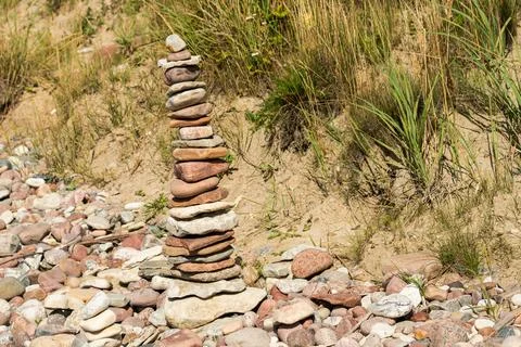 High stone cairn pyramid balanced on a pebble beach Stock Photos