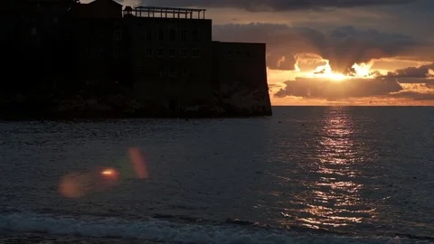 A high stone castle stands in the middle of the pond at sunset Stock Footage 74734049