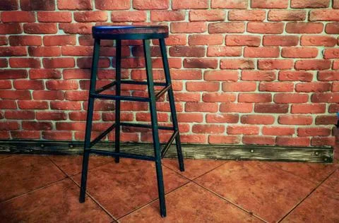 High stool against the background of a red brick wall Stock Photos