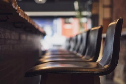 High stools aligned in front of the counter of a restaurant Stock Photos