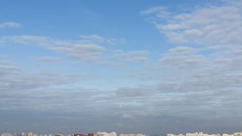 High summer blue sky with soft white clouds on the distant sityscape background 스톡 동영상 120648156