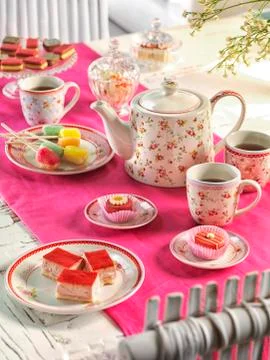 High tea on a table with a pink tablecloth Stock Photos