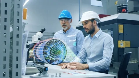 In High Tech Futuristic Factory Two Engineers Works with Holographic Projection  Stock Footage 82252346