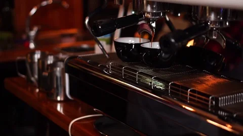 High technology modern coffee machine pouring espresso in two little black cups Stock Footage 105453452