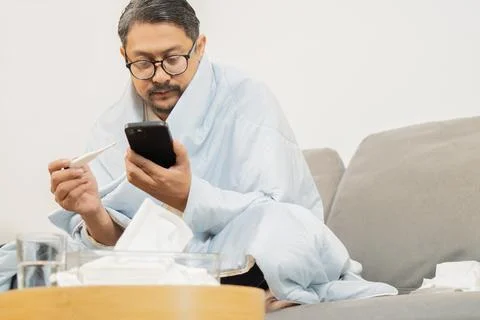 High temperature concept. Man feels serious and check influenza information.. Stock Photos