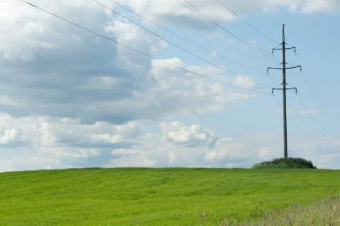 High-tension poles on background clouds Stock Photos