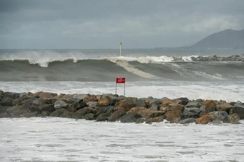 High tide and big waves crash over rocks. Stock Photos