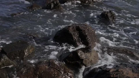 High tide water hitting rocks on the beach Stock Footage 75736505