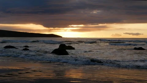 High tide waves on a rocky beach at sunset Video stock 246389669