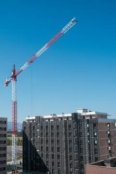 High tower crane at building construction site under blue sky. 写真素材
