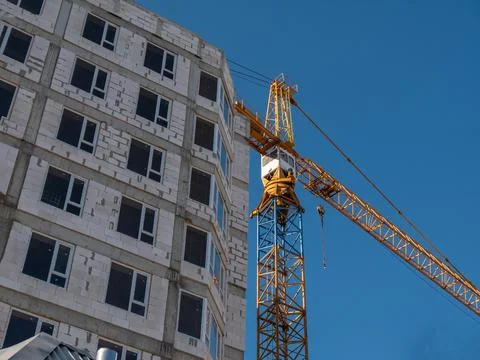 High tower crane on the construction of a multi-storey residential building. Stock Photos