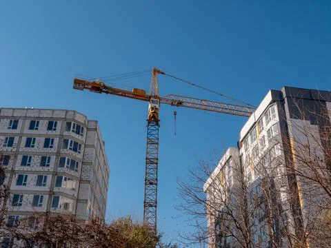 High tower crane on the construction of a multi-story residential building. Stock Photos